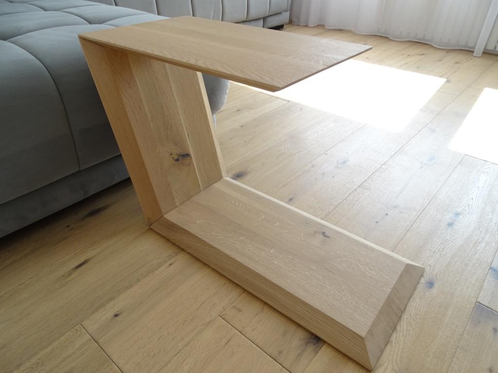 Couchtisch in Trapezform und U-Form der neben einem Sofa steht.