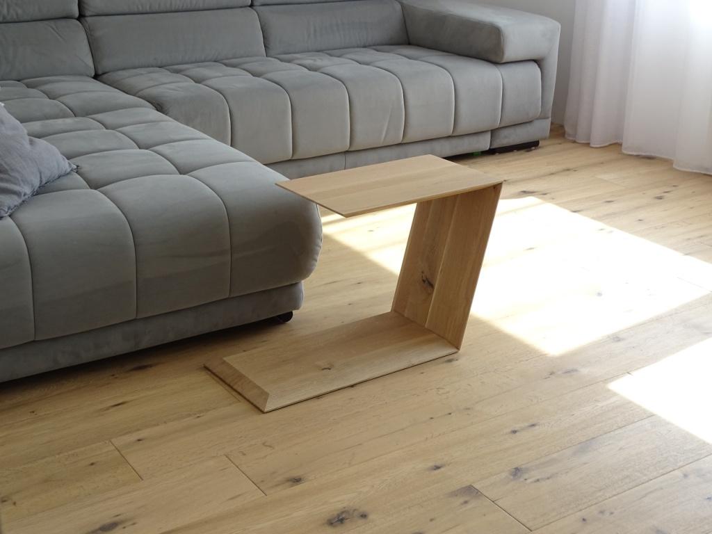 Couchtisch in Trapezform und U-Form der neben dem Sofa steht.