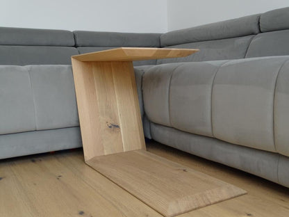 Couchtisch in Trapezform und U-Form der neben einem Sofa steht.